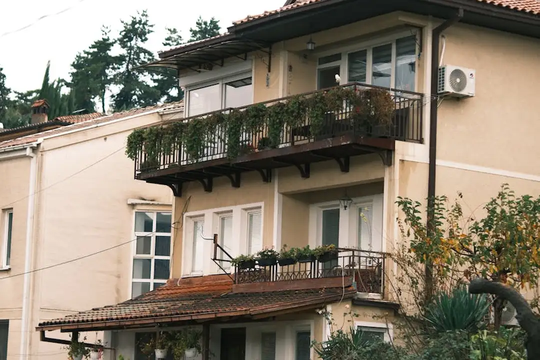 Exterior view of a multi-unit residential building with balconies and greenery
