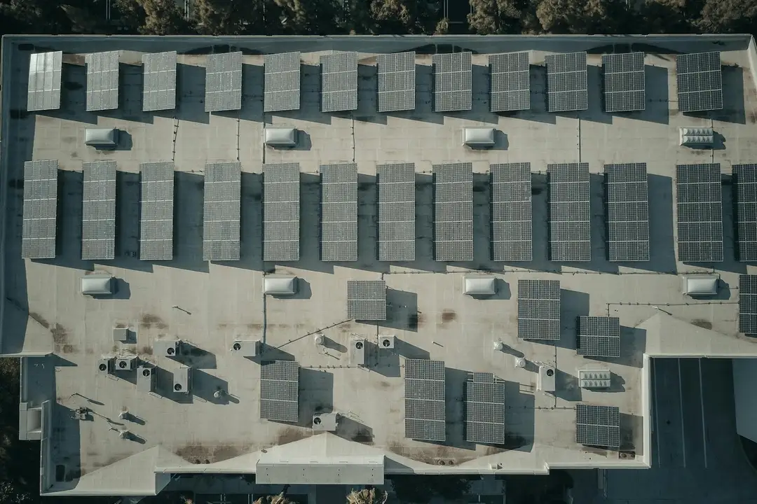 Aerial view of a building rooftop densely covered with solar panels.