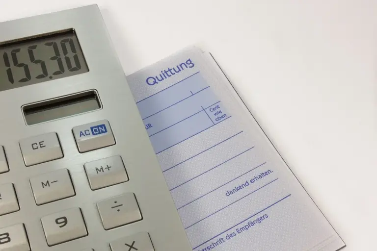 Close-up of a calculator and a receipt-like document, suggesting financial calculations and accounting